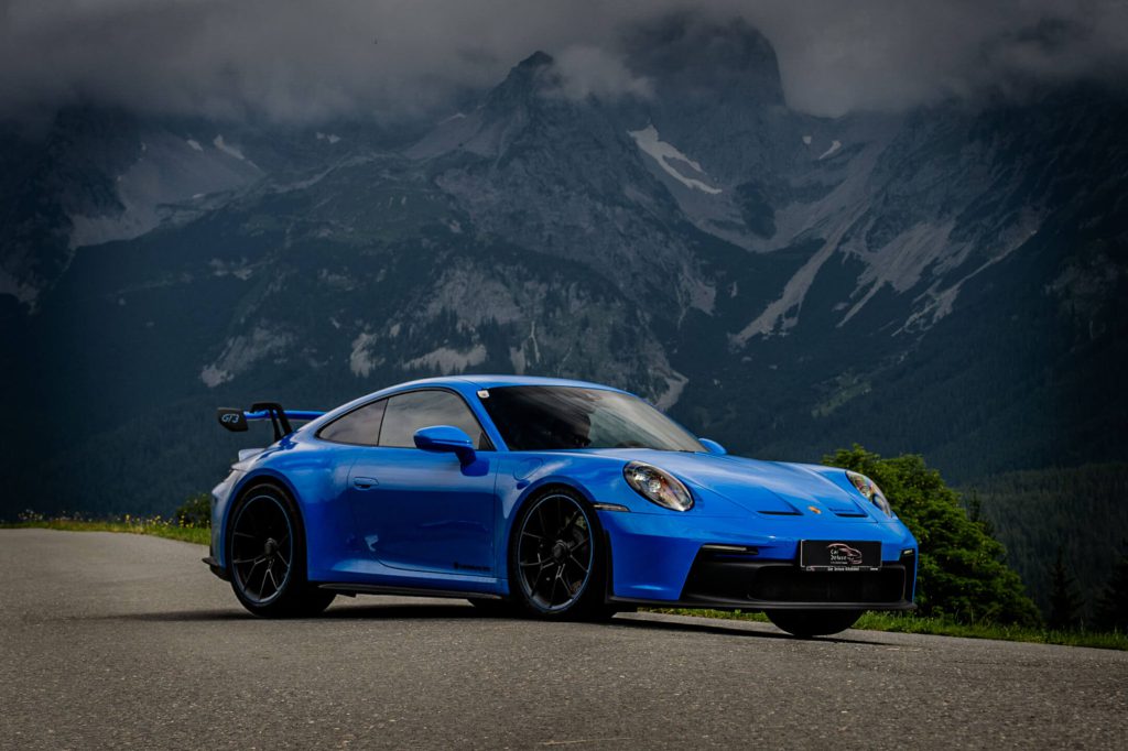 Blauer Porsche Sportwagen vor Alpenkulisse, Luxusautos Kitzbühel, Premium Sportwagen mieten